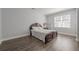 Cozy bedroom with decorative headboard, accent lamp, and a window for natural light at 1913 Shenley Park Ln, Duluth, GA 30097