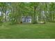View of a storage shed in the backyard, surrounded by lush greenery and a well-manicured lawn at 2000 Mcconnell Rd, Grayson, GA 30017