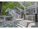 Backyard with multiple decks, staircases, shade trees, and gray siding at 2000 Mcconnell Rd, Grayson, GA 30017