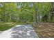 Backyard featuring a concrete patio area, stone structure, mature trees and a well-maintained lawn at 2000 Mcconnell Rd, Grayson, GA 30017