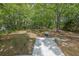 Backyard features a hammock, stone area, and storage shed all set against a backdrop of mature trees at 2000 Mcconnell Rd, Grayson, GA 30017