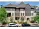 Stylish townhome with a covered porch, a gray roof, and landscaped surroundings at 6596 Aria Village Dr # 642, Atlanta, GA 30328