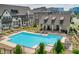 Community pool with lounge chairs, surrounded by a black metal fence and landscaped greenery at 6596 Aria Village Dr # 642, Atlanta, GA 30328