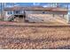 Back exterior view of home with deck, beige siding, walkout basement, and a leaf-covered lot at 9224 Snipe Ln, Jonesboro, GA 30236