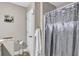 Neutral bathroom featuring a shower with decorative curtain, toilet, and storage at 9224 Snipe Ln, Jonesboro, GA 30236