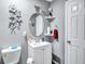 Modern bathroom with white vanity, round mirror, and elegant floral art at 9224 Snipe Ln, Jonesboro, GA 30236