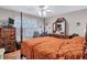 Well-lit bedroom with a four-poster bed, wood floors, dresser, and a ceiling fan at 9224 Snipe Ln, Jonesboro, GA 30236