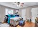 This bedroom provides a comfortable space with natural light, hardwood flooring, and a ceiling fan for added comfort at 9224 Snipe Ln, Jonesboro, GA 30236
