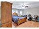 Well-lit bedroom featuring hardwood floors, a ceiling fan, a wood frame bed with blue comforter and an office space at 9224 Snipe Ln, Jonesboro, GA 30236