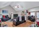 The spacious living room boasts vaulted ceilings, a ceiling fan, hardwood floors and comfortable, modern furniture at 9224 Snipe Ln, Jonesboro, GA 30236