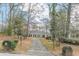 View of a home from a long cracked driveway surrounded by mature trees at 3390 Somerset Sw Trl, Atlanta, GA 30331
