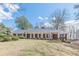 Charming brick home featuring a welcoming front porch with large white columns and shuttered windows at 3390 Somerset Sw Trl, Atlanta, GA 30331