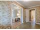 View of a hallway featuring floral wallpaper and doorways leading to a bedroom and bathroom at 3390 Somerset Sw Trl, Atlanta, GA 30331