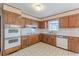 Traditional kitchen with wood cabinets, tile floors, and vintage appliances at 3390 Somerset Sw Trl, Atlanta, GA 30331