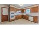 Traditional kitchen with wood cabinets, tile floors, and vintage appliances at 3390 Somerset Sw Trl, Atlanta, GA 30331