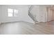 Spacious living room featuring light gray wood-look floors and a staircase at 4212 Adler Cir, Buford, GA 30519