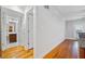 Bright hallway leading to a bathroom with hardwood floors and white walls at 48 Peachtree Ne Ave # 412, Atlanta, GA 30305