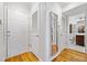 Hallway leading to a bathroom with wood floors and white doors at 48 Peachtree Ne Ave # 412, Atlanta, GA 30305