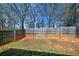 View of the spacious backyard with a wooden fence, offering privacy and outdoor space at 6450 Wellington Chase Ct, Lithonia, GA 30058