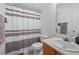 Bathroom with a white vanity, toilet, and striped shower curtain at 6450 Wellington Chase Ct, Lithonia, GA 30058