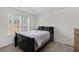 Cozy bedroom featuring a comfortable bed, large window and neutral carpet flooring, creating a tranquil retreat at 6450 Wellington Chase Ct, Lithonia, GA 30058