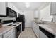 Functional kitchen with white cabinets and modern appliances including black microwave and stove at 6450 Wellington Chase Ct, Lithonia, GA 30058