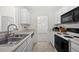 White galley kitchen with modern appliances, ample storage and view to the living room at 6450 Wellington Chase Ct, Lithonia, GA 30058