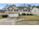 Charming split-level home with manicured lawn, two-car garage, and inviting front porch at 174 Whetstone Way, Villa Rica, GA 30180