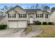 Charming split-level home with manicured lawn, two-car garage, and inviting front porch at 174 Whetstone Way, Villa Rica, GA 30180
