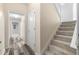 Hallway with wood floors leading to carpeted stairs and white doors at 174 Whetstone Way, Villa Rica, GA 30180