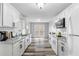 Spacious kitchen features white cabinets, granite countertops, and stainless steel microwave at 174 Whetstone Way, Villa Rica, GA 30180
