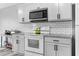 Bright kitchen features white cabinets, granite countertops, and stainless steel microwave at 174 Whetstone Way, Villa Rica, GA 30180