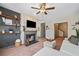 Cozy living room with fireplace, TV, ceiling fan, and stylish decor at 407 The Crossings Ln, Woodstock, GA 30189