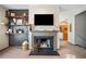 Living room featuring a fireplace with TV, floating shelves and access to other rooms at 407 The Crossings Ln, Woodstock, GA 30189