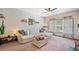 Bright living room with a large sofa, ceiling fan, and decorative rug at 407 The Crossings Ln, Woodstock, GA 30189