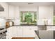 The stylish kitchen features granite counters, white cabinets, and stainless steel appliances at 4183 Paran Pines Nw Dr, Atlanta, GA 30327