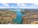 Picturesque aerial view of a sprawling lake with homes nestled along the wooded shoreline at 6313 Shoreland Cir, Buford, GA 30518