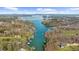 Panoramic aerial view of the lake and surrounding homesites with mountains in the distance at 6313 Shoreland Cir, Buford, GA 30518