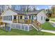 Rear exterior view of a home with a spacious deck, lush landscaping, and well-maintained yard at 6313 Shoreland Cir, Buford, GA 30518