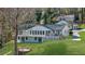 Back exterior view of a home with a spacious deck, well-maintained lawn, and lush trees at 6313 Shoreland Cir, Buford, GA 30518