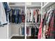 Organized closet features rods with hanging shirts, pants and clothing at 6313 Shoreland Cir, Buford, GA 30518