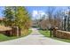 Gated entrance with a long driveway that leads to a beautiful home on a lush green lawn at 6313 Shoreland Cir, Buford, GA 30518