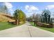 Long driveway leading to a charming home with a stone gated entrance, lush green lawn, and mature trees at 6313 Shoreland Cir, Buford, GA 30518