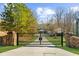 Gated entrance featuring stone pillars and black metal gate leading to the property at 6313 Shoreland Cir, Buford, GA 30518