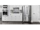 Well-appointed kitchen boasts stainless steel appliances, white cabinets, and gas cooktop at 6313 Shoreland Cir, Buford, GA 30518