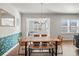 Dining room with wooden table and bench seating, bright windows, and decorative wall covering at 1436 Maston Rd, Auburn, GA 30011