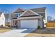 Side view of a well-maintained two-story home with a spacious driveway leading to an attached two-car garage at 1436 Maston Rd, Auburn, GA 30011