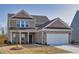 Traditional brick home featuring a well-manicured lawn, a two-car garage, and inviting front porch at 1436 Maston Rd, Auburn, GA 30011