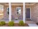 Inviting front porch with brick facade, cozy seating, and a welcoming entrance door at 1436 Maston Rd, Auburn, GA 30011