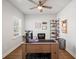 Well-lit home office with modern desk, ceiling fan, and hardwood floors for a productive workspace at 1436 Maston Rd, Auburn, GA 30011